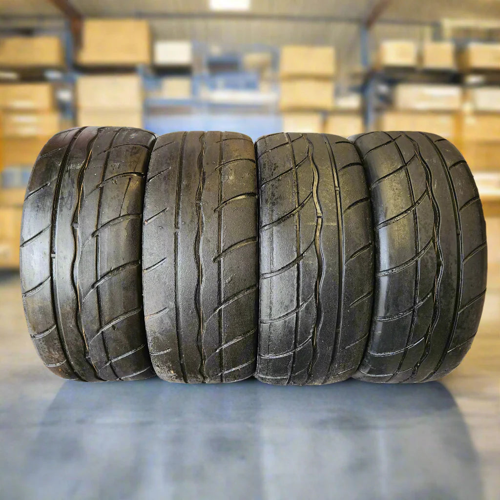 Four tires stacked on a surface with Tyretek branding in the background.